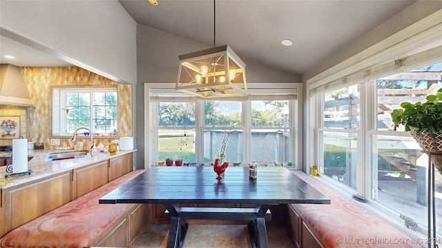 dining space with sink and lofted ceiling