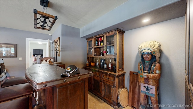 bar with light tile patterned flooring and a textured ceiling