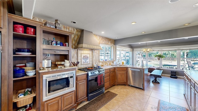 kitchen with custom exhaust hood, a wealth of natural light, decorative light fixtures, and appliances with stainless steel finishes