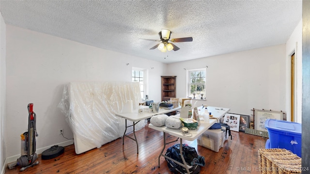 dining space featuring hardwood / wood-style floors, ceiling fan, and a textured ceiling