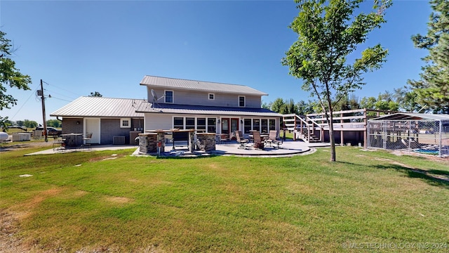 rear view of property with a yard, a patio, and area for grilling