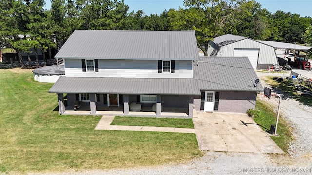 view of front of property with a covered pool, a front lawn, an outdoor structure, and a garage