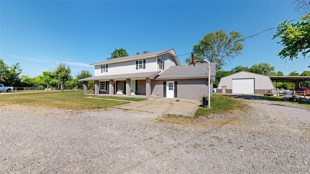 view of front of property featuring an outbuilding, a front yard, a porch, and a garage