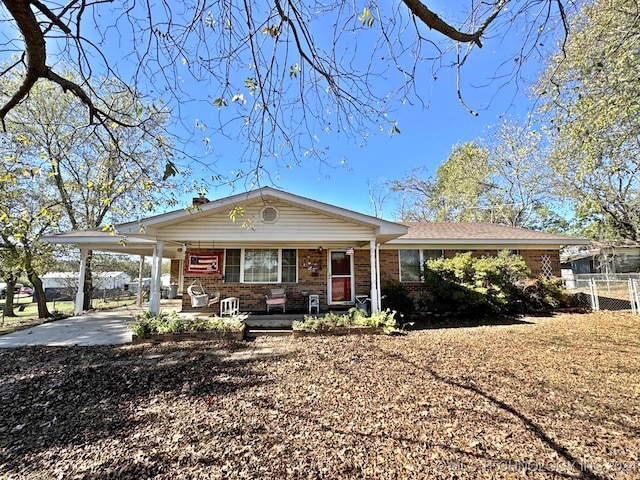 ranch-style house with a porch and a carport