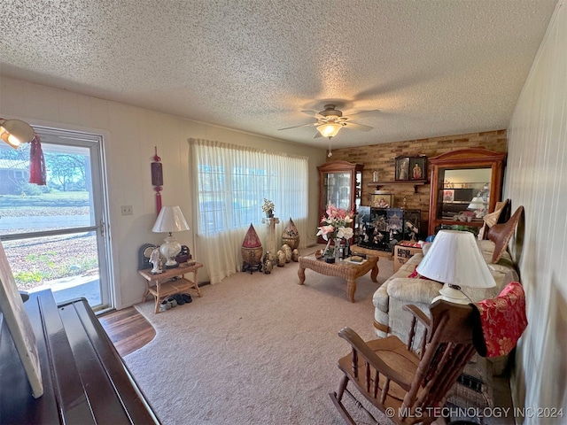 living room with ceiling fan, carpet, and a textured ceiling