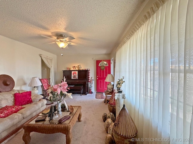 living room featuring ceiling fan, carpet floors, and a textured ceiling