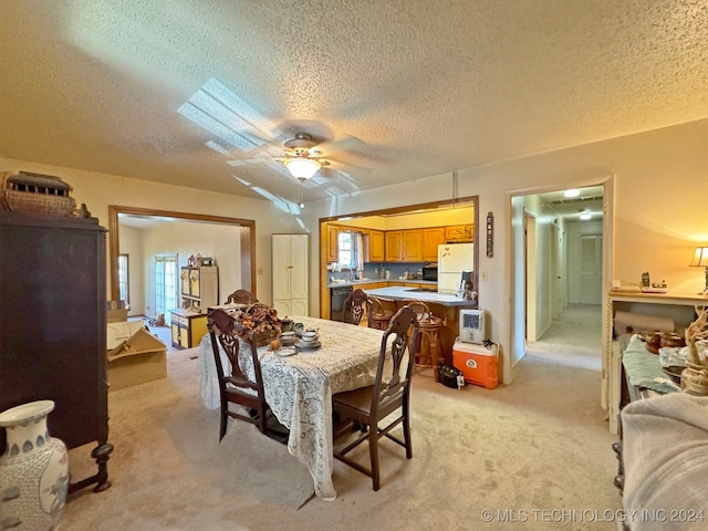 carpeted dining space with ceiling fan and a textured ceiling