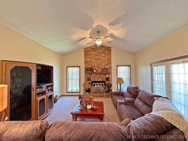 living room with light carpet, a textured ceiling, a large fireplace, vaulted ceiling, and ceiling fan