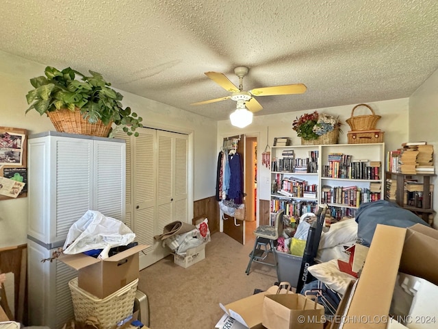 interior space featuring carpet flooring, a textured ceiling, and ceiling fan