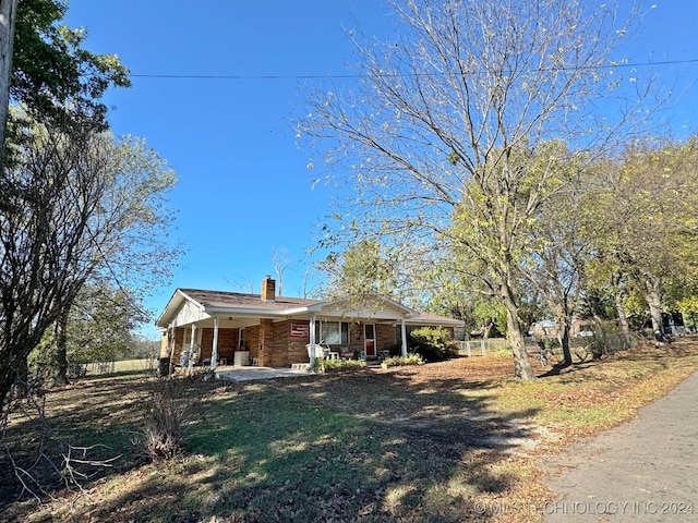 613 S Rodgers St, Vian, OK 74962 - ranch-style home with covered porch, a chimney, and brick siding