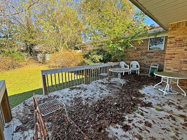 wooden terrace featuring a yard