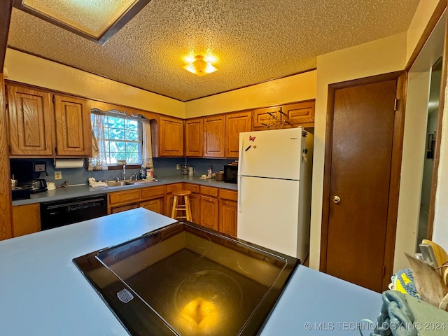 kitchen featuring black dishwasher, a textured ceiling, white refrigerator, and sink