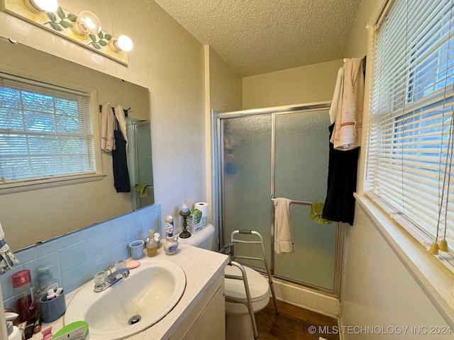 bathroom with decorative backsplash, toilet, an enclosed shower, and a textured ceiling