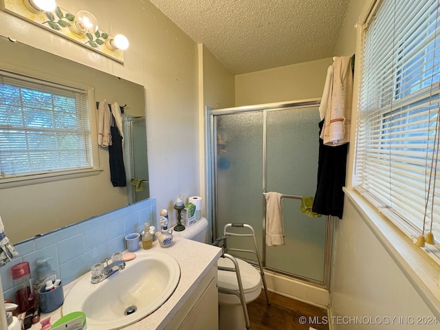 613 S Rodgers St, Vian, OK 74962 - full bathroom with a textured ceiling, vanity, a stall shower, and wood finished floors