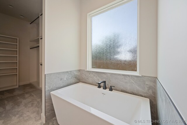 bathroom featuring a tub to relax in and plenty of natural light