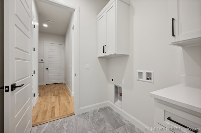 washroom with cabinets, hookup for an electric dryer, and hookup for a washing machine