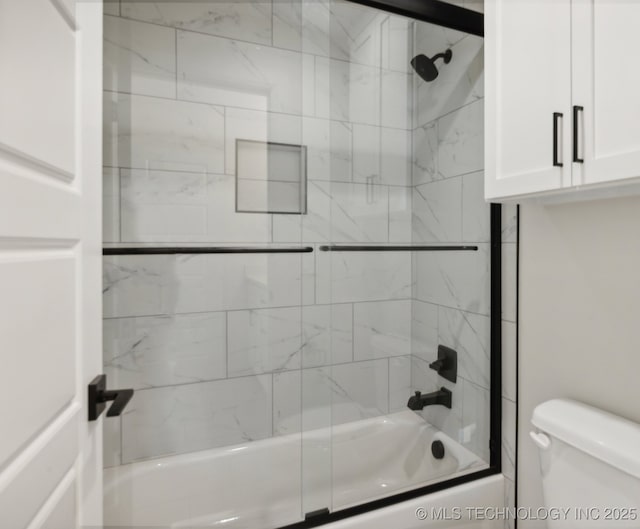 bathroom featuring bath / shower combo with glass door and toilet