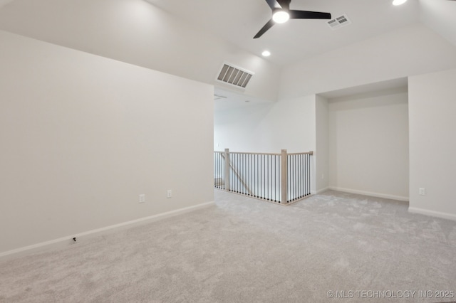 empty room featuring ceiling fan, light colored carpet, and lofted ceiling