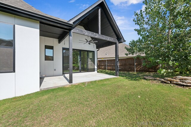 rear view of house with a yard, ceiling fan, and a patio area