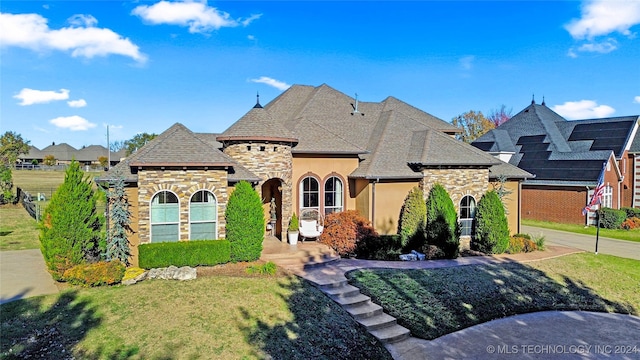 french country style house with a front yard