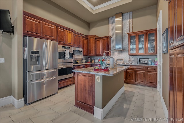 kitchen featuring tasteful backsplash, light stone counters, stainless steel appliances, wall chimney range hood, and a center island