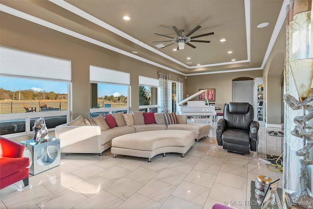 living room featuring a tray ceiling and ceiling fan