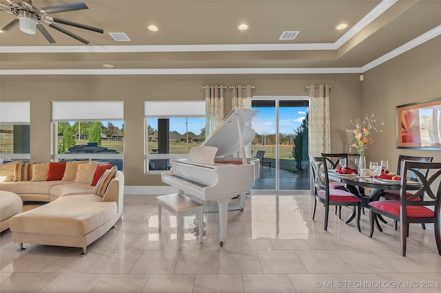 living room featuring a tray ceiling, a wealth of natural light, crown molding, and ceiling fan