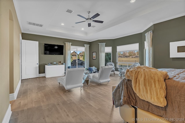 bedroom featuring a raised ceiling, ceiling fan, crown molding, and light hardwood / wood-style floors