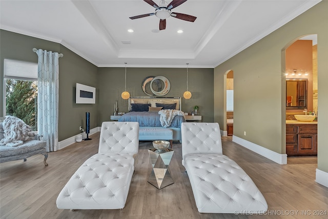 bedroom with light hardwood / wood-style floors, ensuite bath, ceiling fan, and ornamental molding