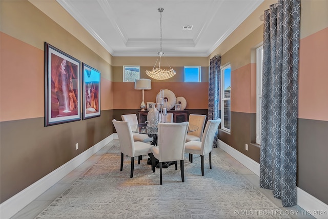 tiled dining space with crown molding and a tray ceiling