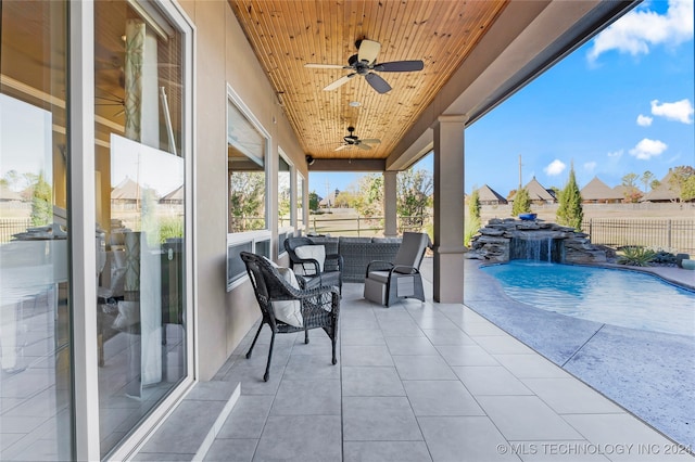 view of patio with outdoor lounge area, pool water feature, a fenced in pool, and ceiling fan