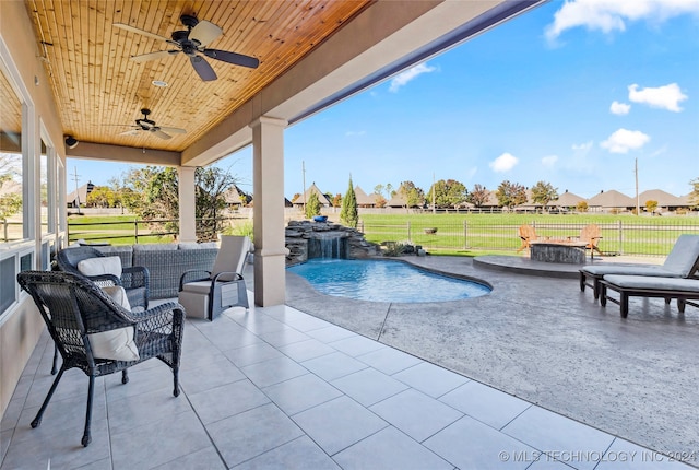 view of swimming pool featuring pool water feature, ceiling fan, an outdoor hangout area, and a patio