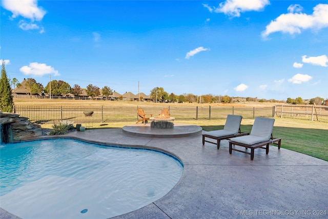 view of pool with pool water feature, a rural view, a fire pit, a patio, and a lawn