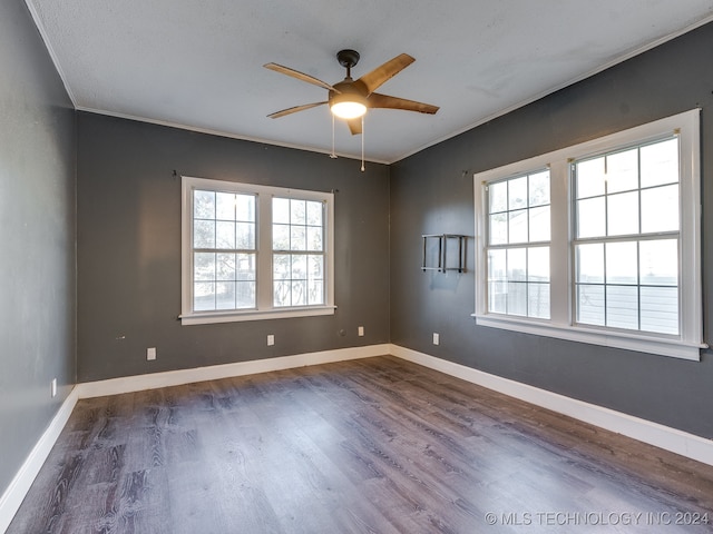 empty room featuring dark hardwood / wood-style floors, ceiling fan, plenty of natural light, and crown molding