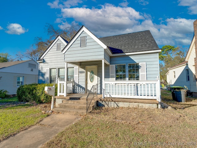 bungalow featuring a front lawn and a porch