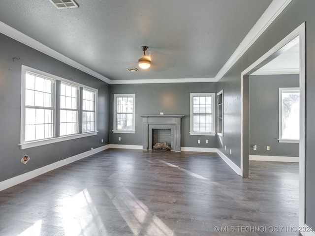 unfurnished living room featuring a fireplace, dark hardwood / wood-style flooring, a healthy amount of sunlight, and a textured ceiling