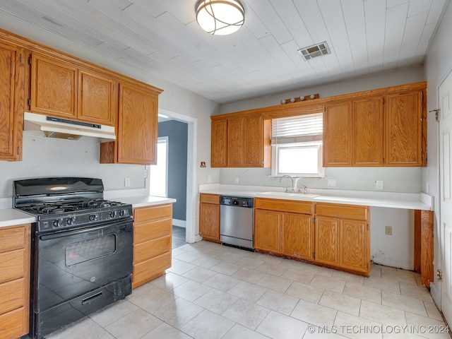 kitchen with black gas range, dishwasher, light tile patterned floors, and sink