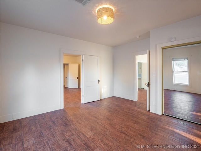 spare room with dark wood-type flooring