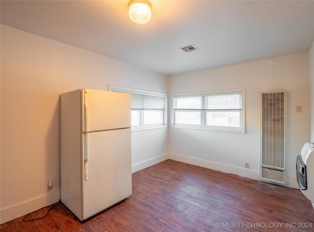 kitchen featuring white refrigerator, dark hardwood / wood-style flooring, a wealth of natural light, and heating unit