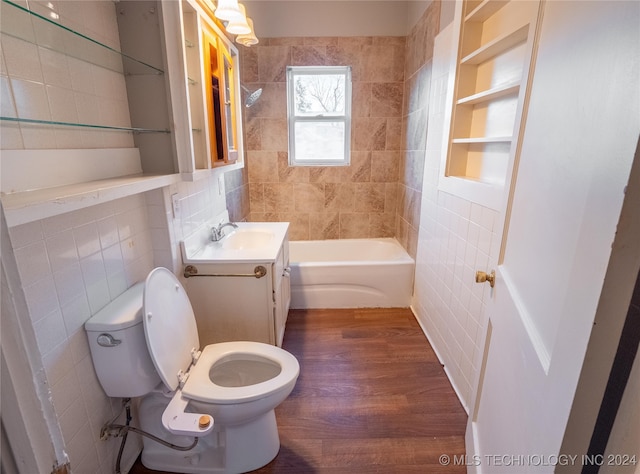 full bathroom with toilet, shower / tub combination, vanity, tile walls, and hardwood / wood-style flooring