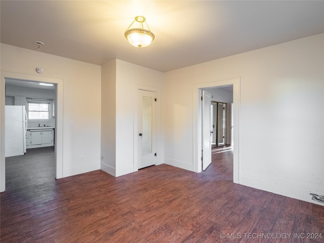 unfurnished room featuring dark hardwood / wood-style floors and sink