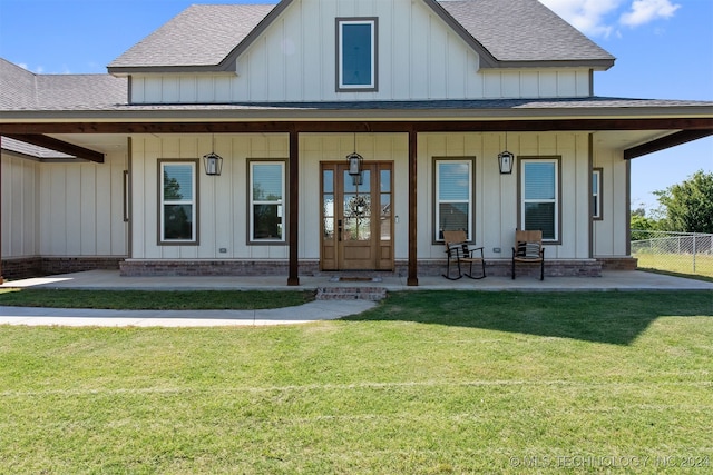 back of property featuring a lawn and a porch