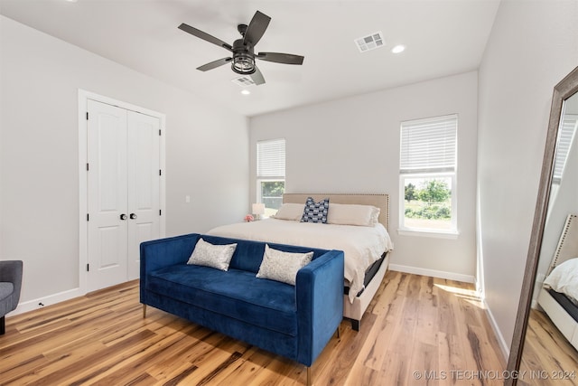 bedroom featuring a closet, light hardwood / wood-style flooring, and ceiling fan