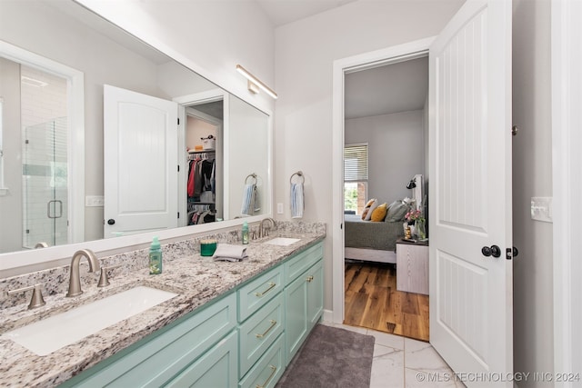 bathroom with vanity, hardwood / wood-style flooring, and a shower with door