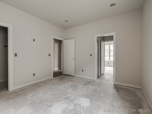 unfurnished bedroom with a spacious closet