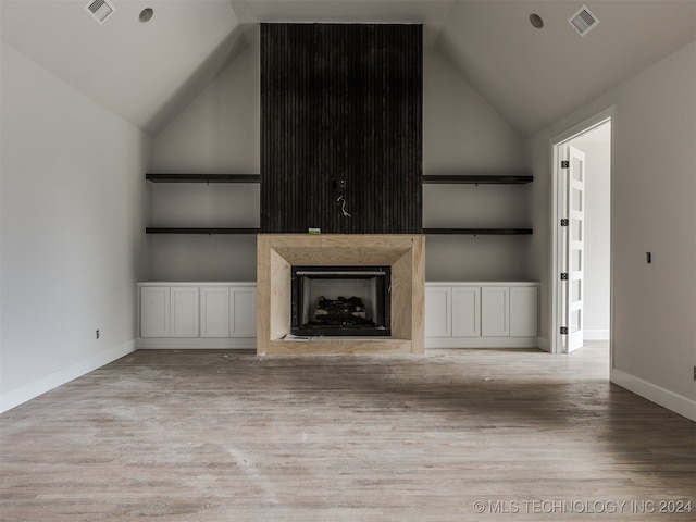 unfurnished living room featuring light hardwood / wood-style flooring, high vaulted ceiling, and built in features