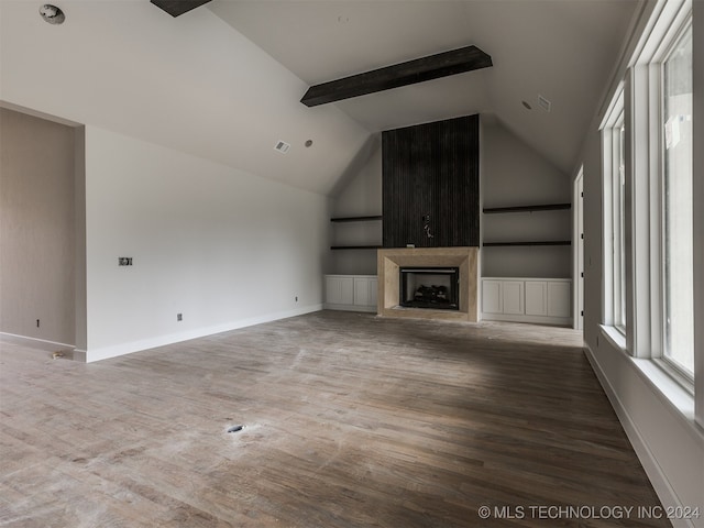 unfurnished living room featuring built in features, beam ceiling, hardwood / wood-style flooring, and high vaulted ceiling