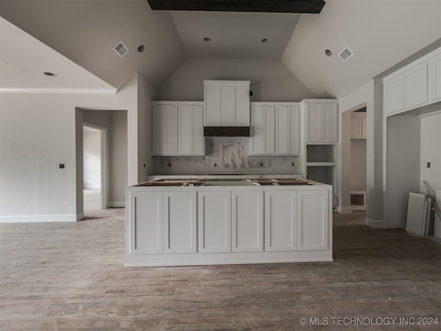 kitchen featuring a kitchen island, white cabinetry, high vaulted ceiling, and light hardwood / wood-style flooring