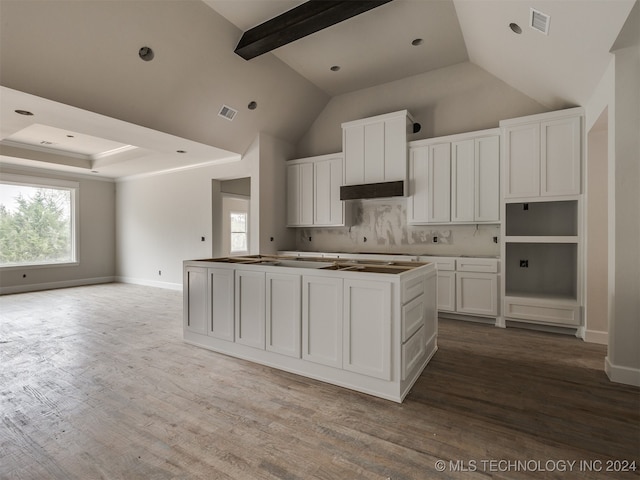 kitchen with a center island, backsplash, high vaulted ceiling, light wood-type flooring, and white cabinetry