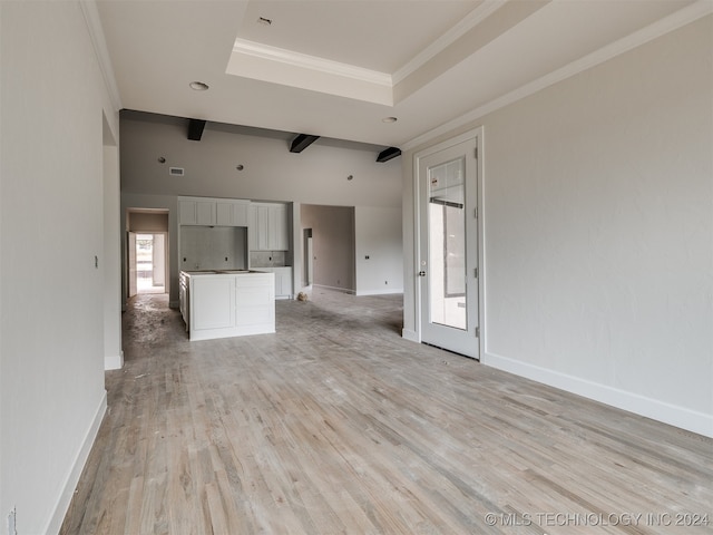 unfurnished living room featuring beam ceiling, a raised ceiling, crown molding, and light hardwood / wood-style flooring